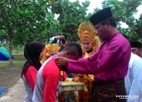 Camat Bantan Syamsul Bahri mengalungkan tanda peserta